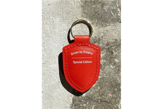 Brelok z herbem „Driven by Dreams” – 75 lat  lava orange